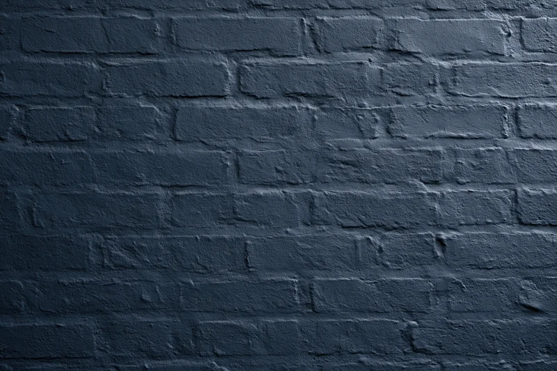 Navy-painted brick wall filling the frame flat-on