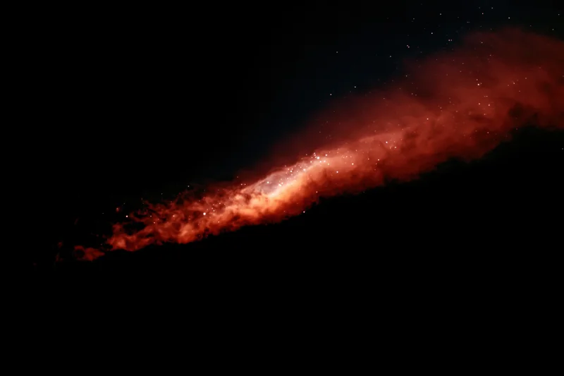 Diagonal streak of glowing red nebula across dark space