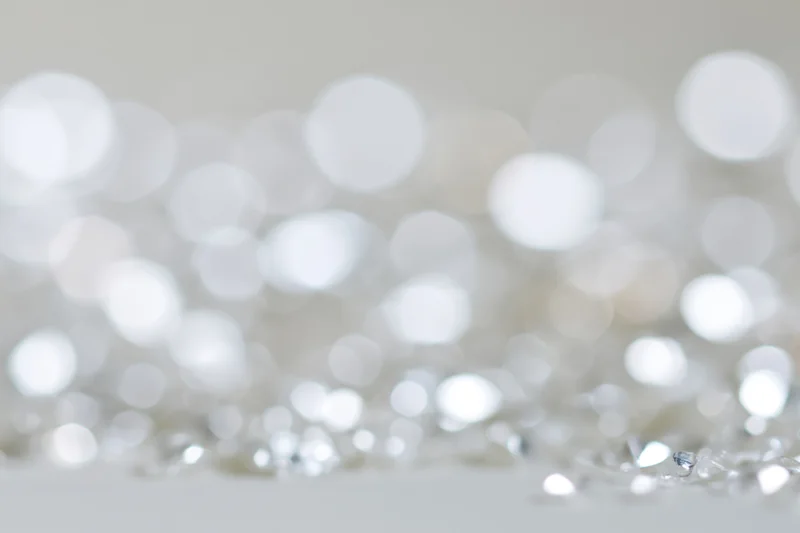 Scattered silver and white light orbs with bokeh effect on a soft background
