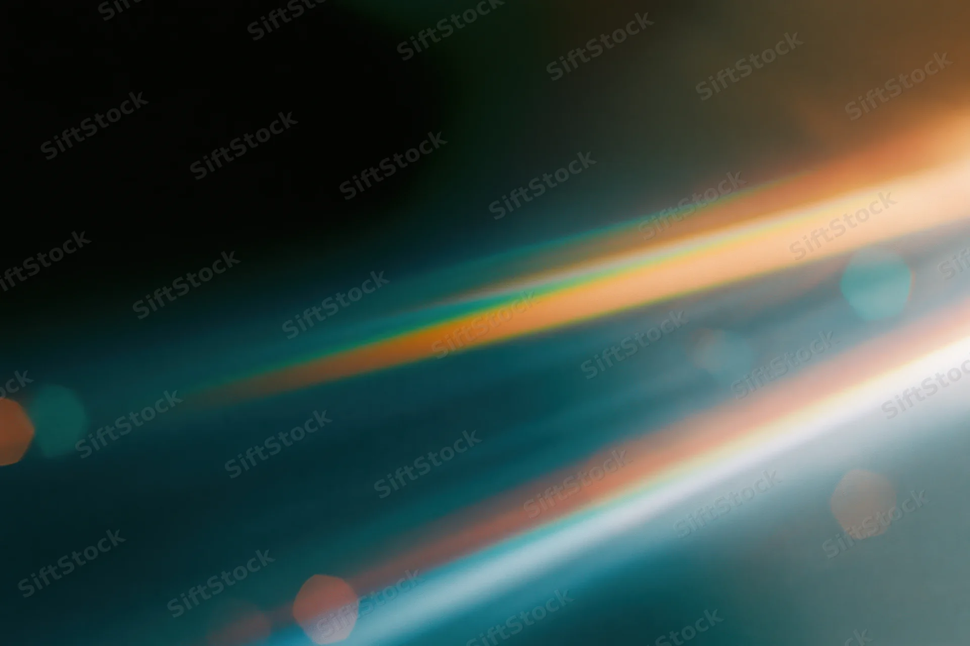 Defocused lens flare with colorful light streaks and bokeh against a dark gradient background