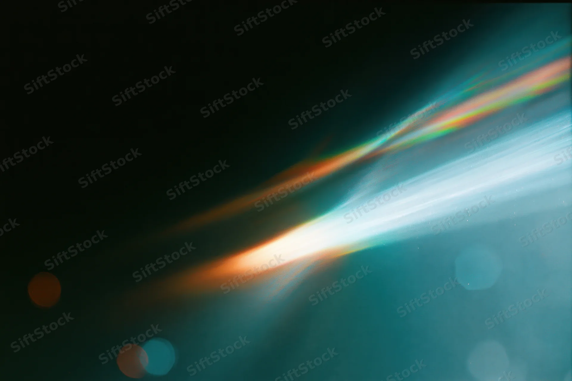 Defocused lens flare with colorful light streaks and bokeh against dark background