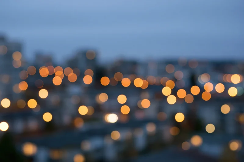 Blurred city lights at dusk over urban apartment buildings