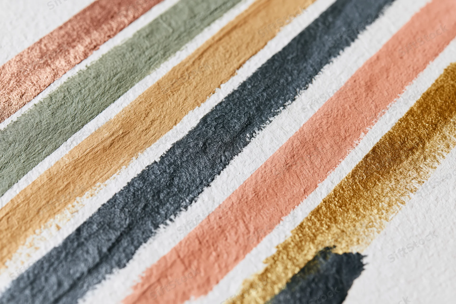 Diagonal paint brushstrokes in earthy tones on textured white paper