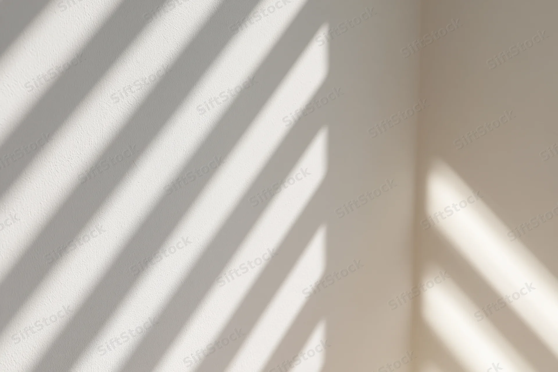 Diagonal stripes of light and shadow cast across a plain interior wall by a window