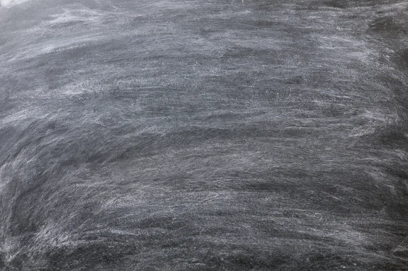 Close-up of empty blackboard surface with chalk residue filling the frame