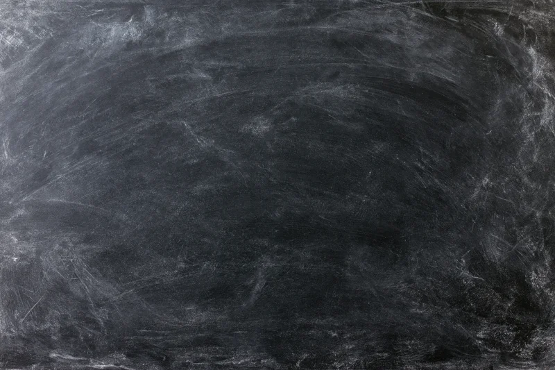 Empty blackboard surface with chalk smudges and scratches filling the frame