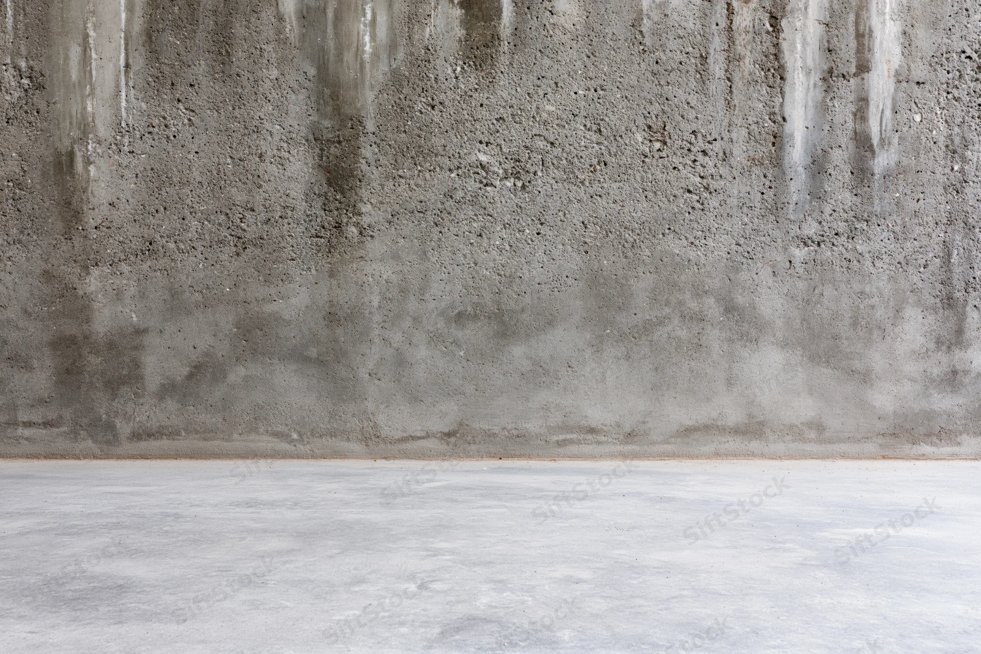 Empty concrete room interior with weathered cement wall and smooth floor