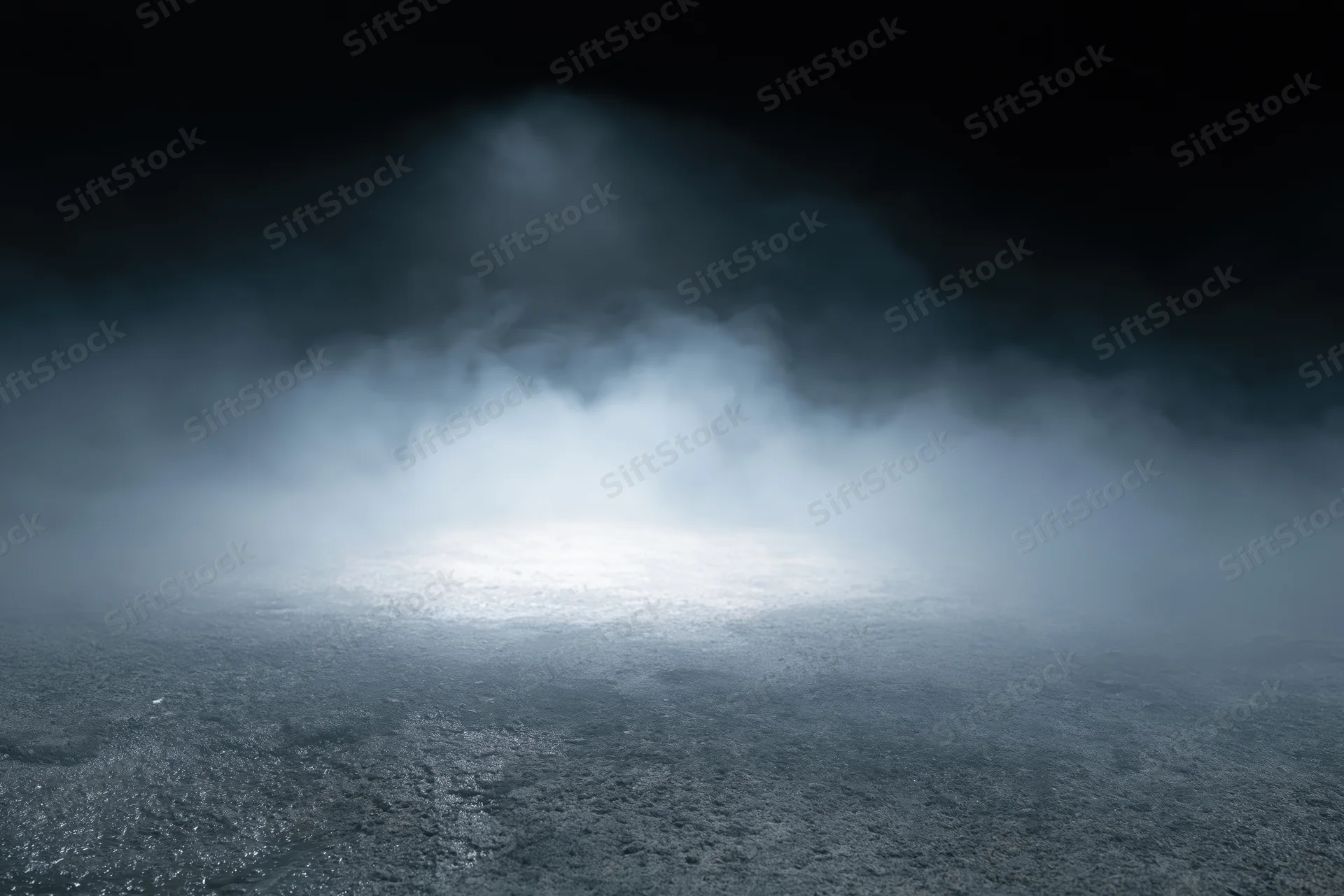 Dark concrete floor with rising white smoke in an empty industrial space