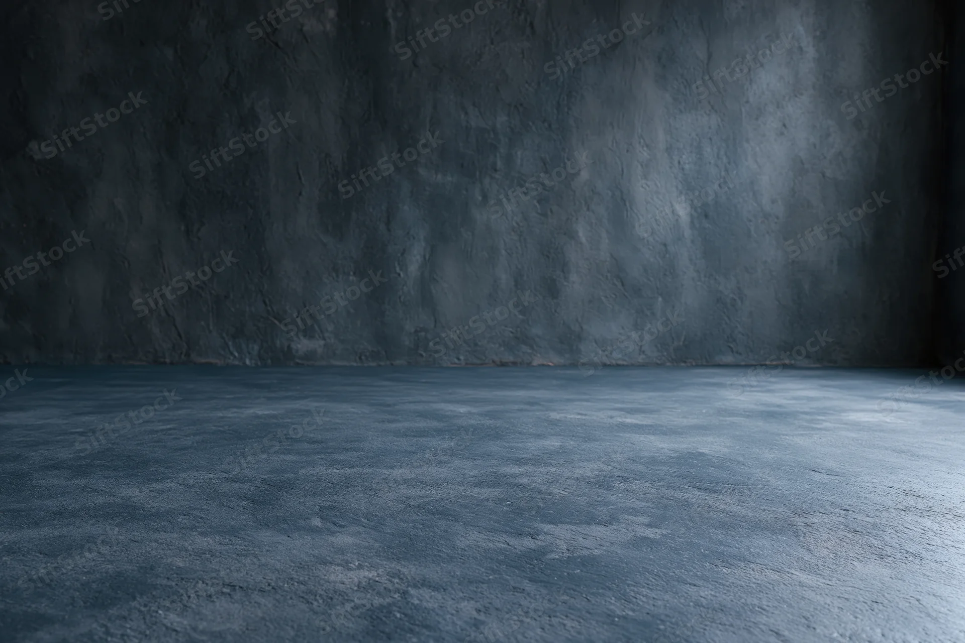 Empty dark concrete room with textured walls and floor meeting at corner