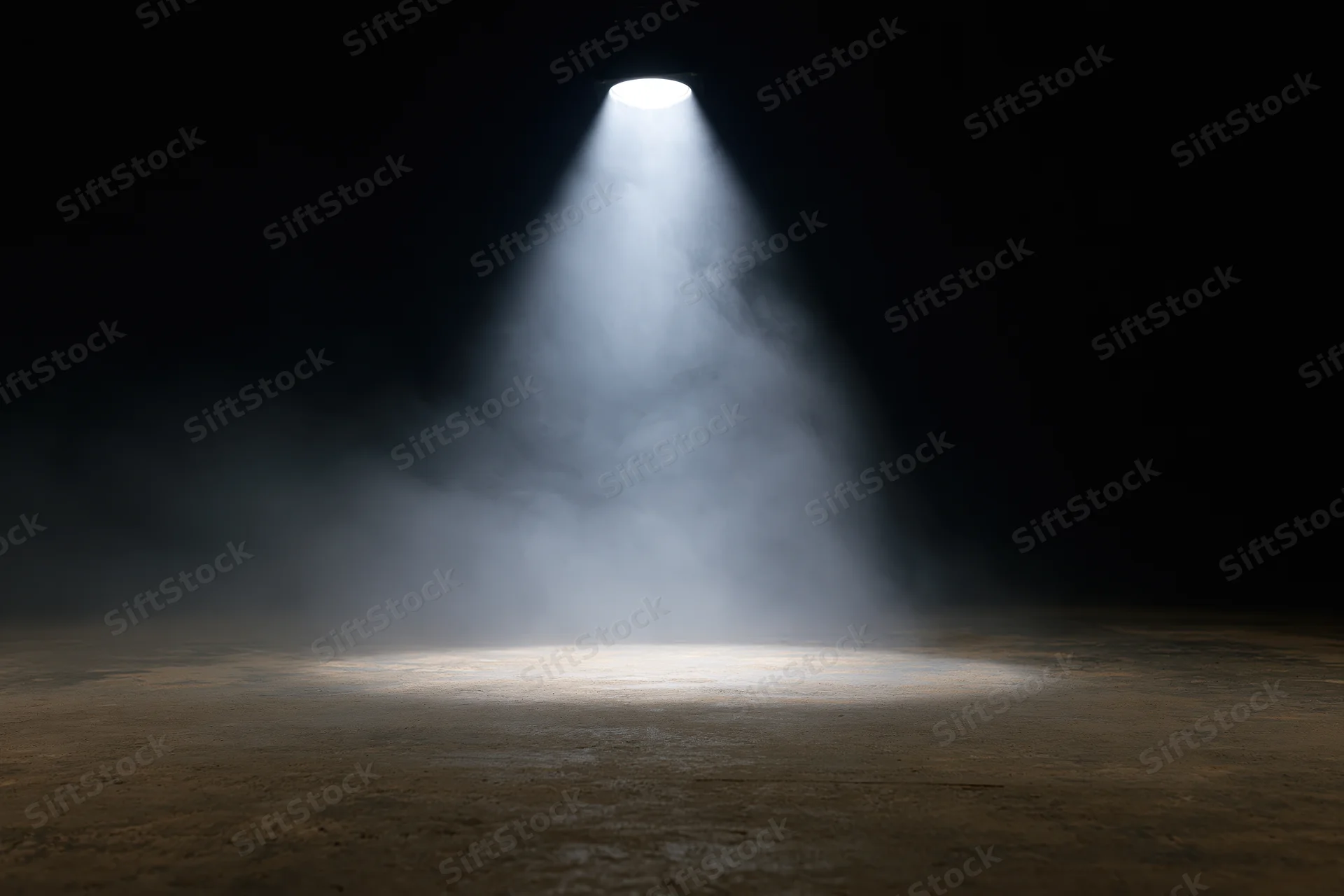 Single overhead spotlight beam illuminating empty dark stage floor
