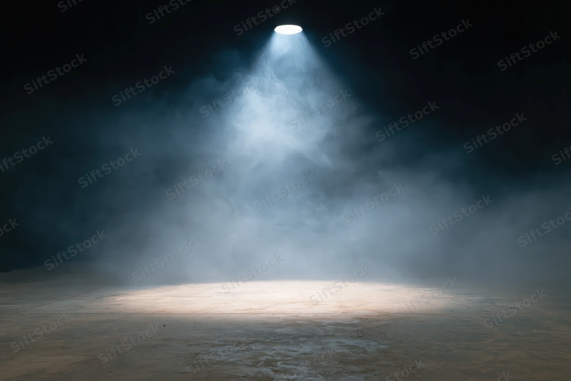 Empty stage illuminated by a single overhead spotlight with smoke drifting across the floor
