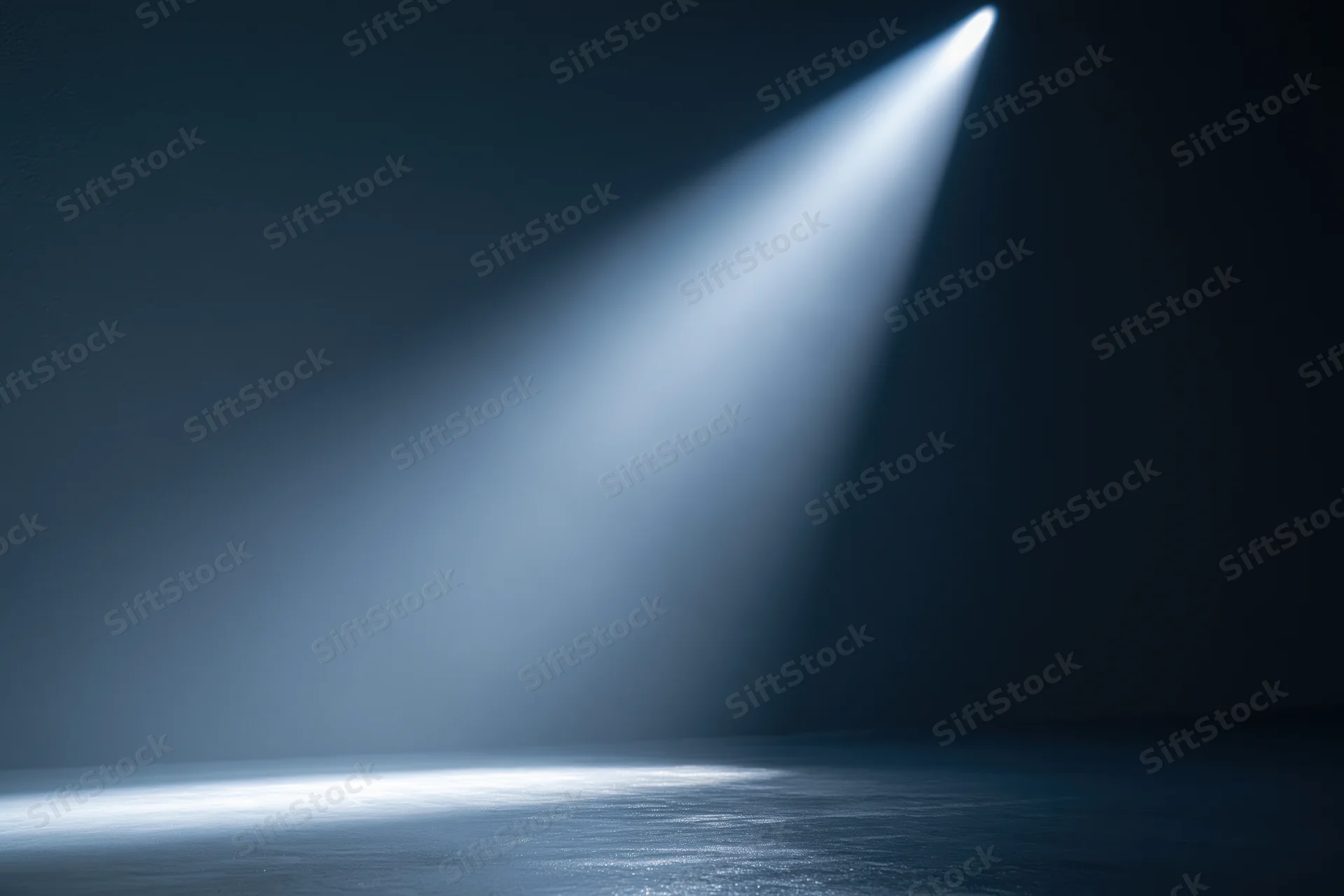 Single spotlight beam illuminating empty dark studio floor with reflection and haze