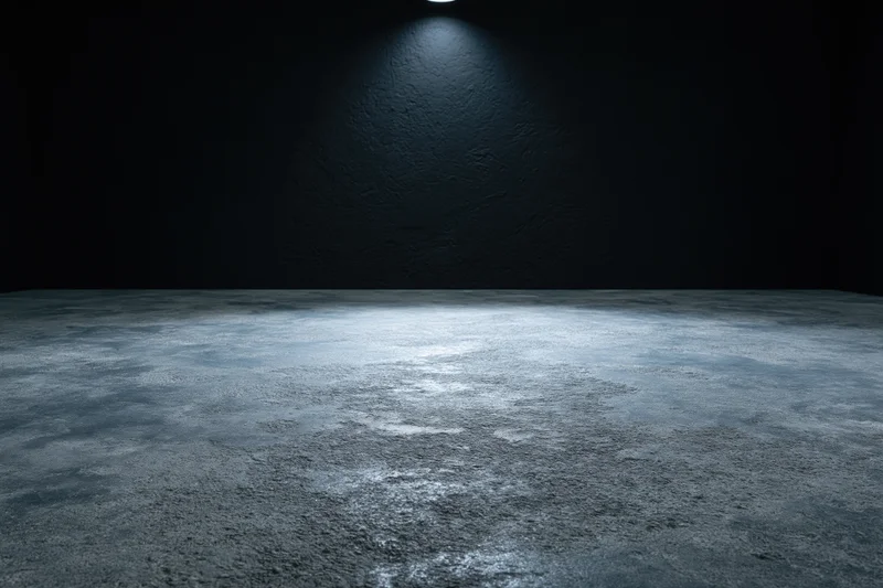Empty dark studio interior with rough concrete floor and spotlight lighting