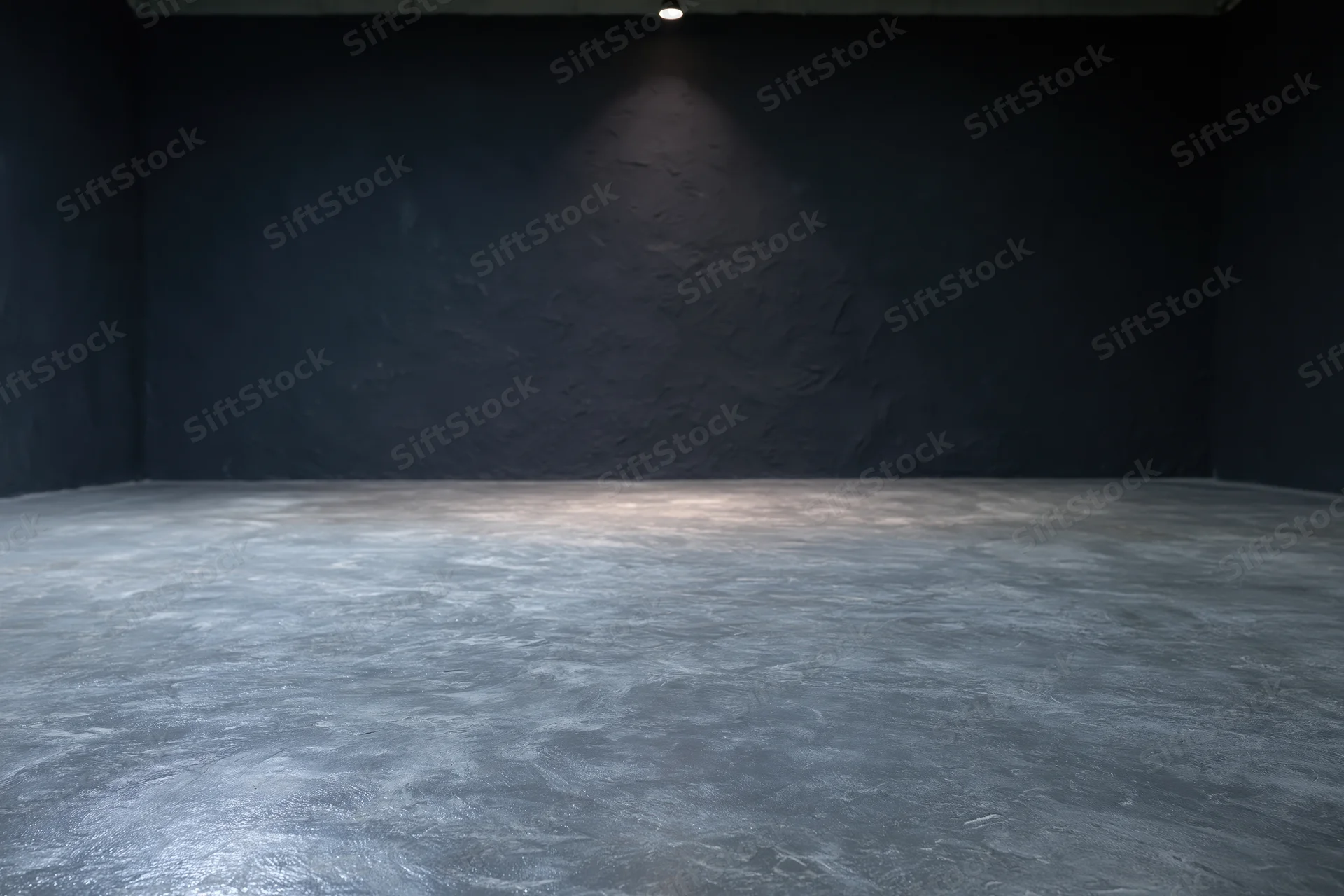 Empty dark studio interior with rough concrete floor and spotlight on textured wall