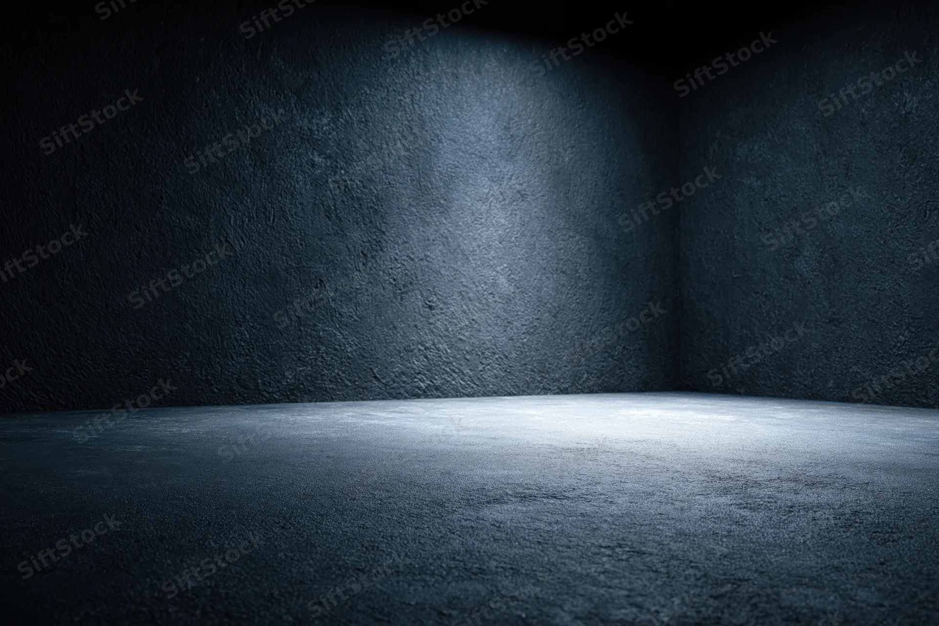 Empty dark studio room with concrete textured walls and floor lit by spotlight in corner