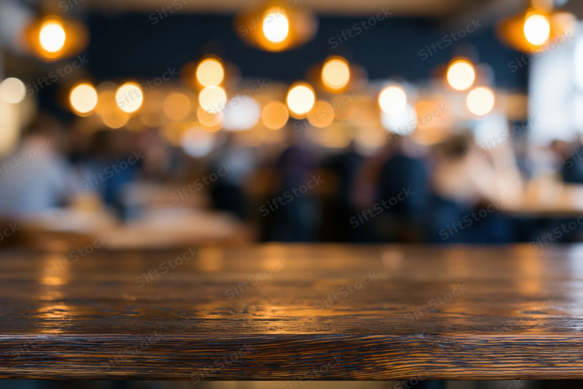 Dark wooden bar counter in sharp focus with blurred patrons and warm lights in background