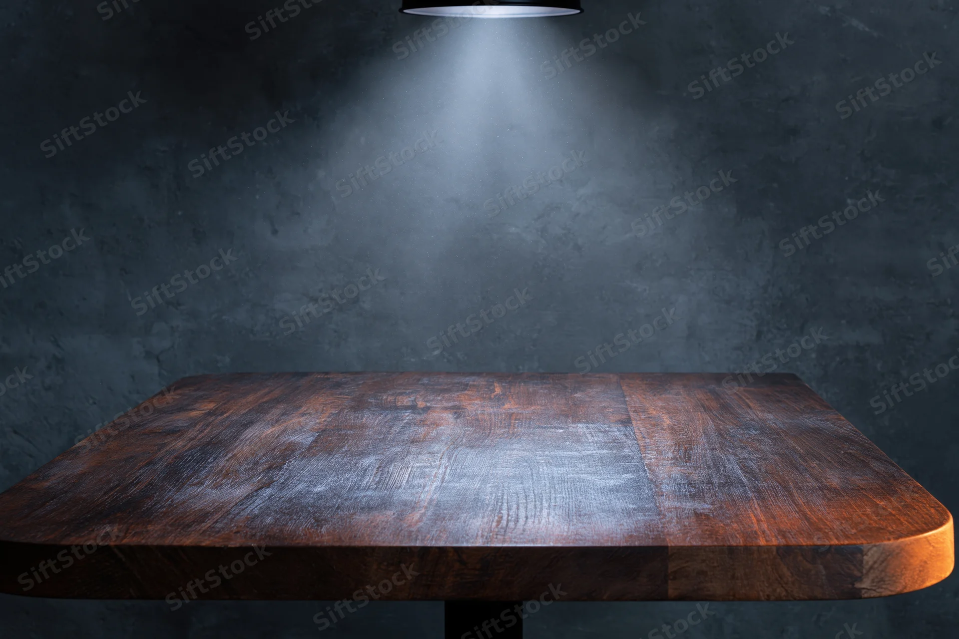 Dark wooden tabletop under spotlight in industrial studio setting