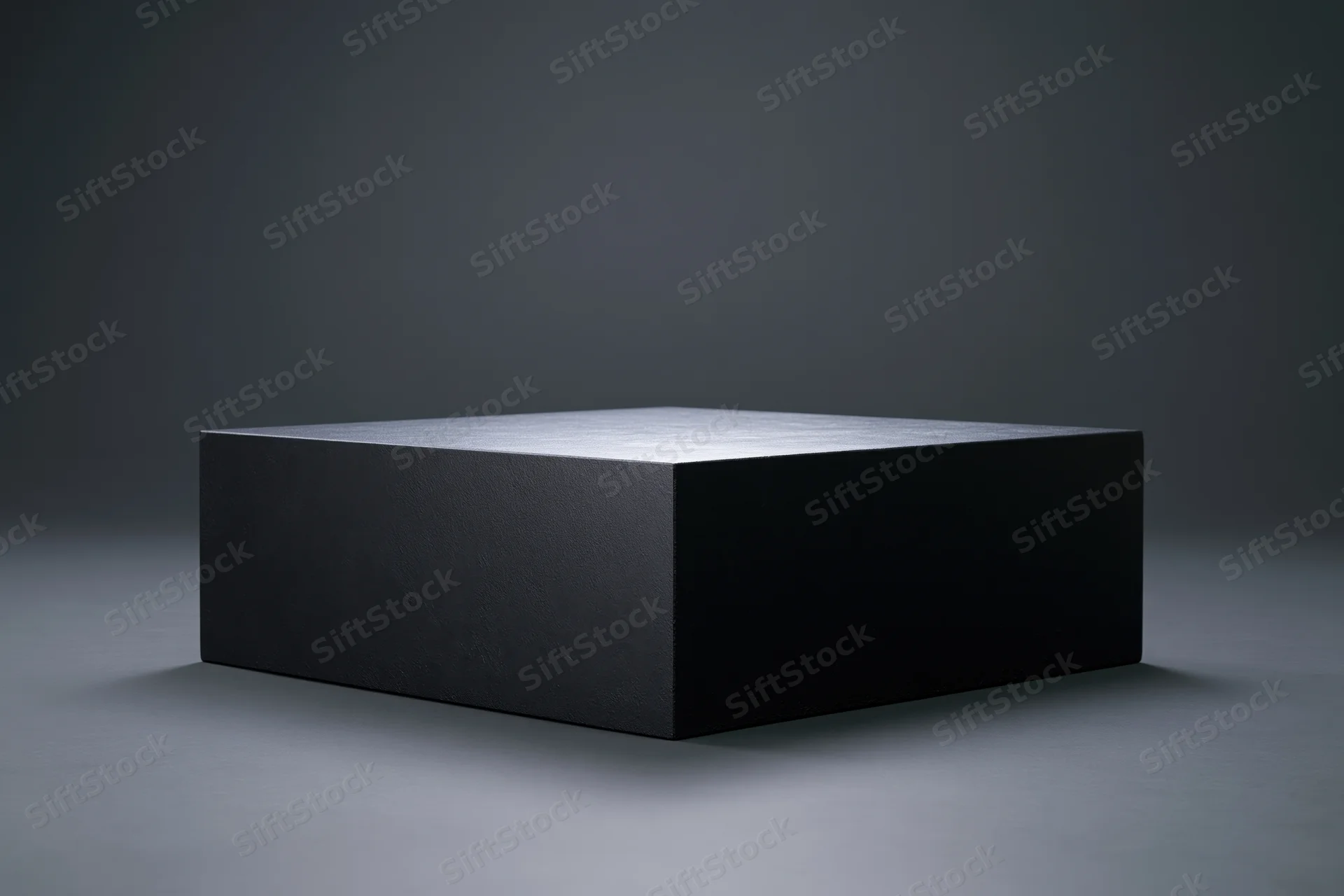 Matte black rectangular display pedestal centered on a gray studio floor