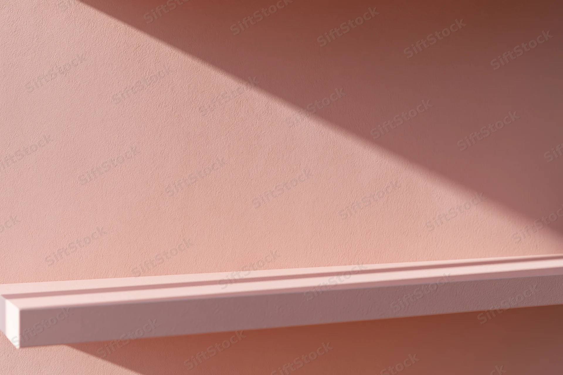 Empty pale pink shelf mounted on a matching matte pink wall in a minimalist interior