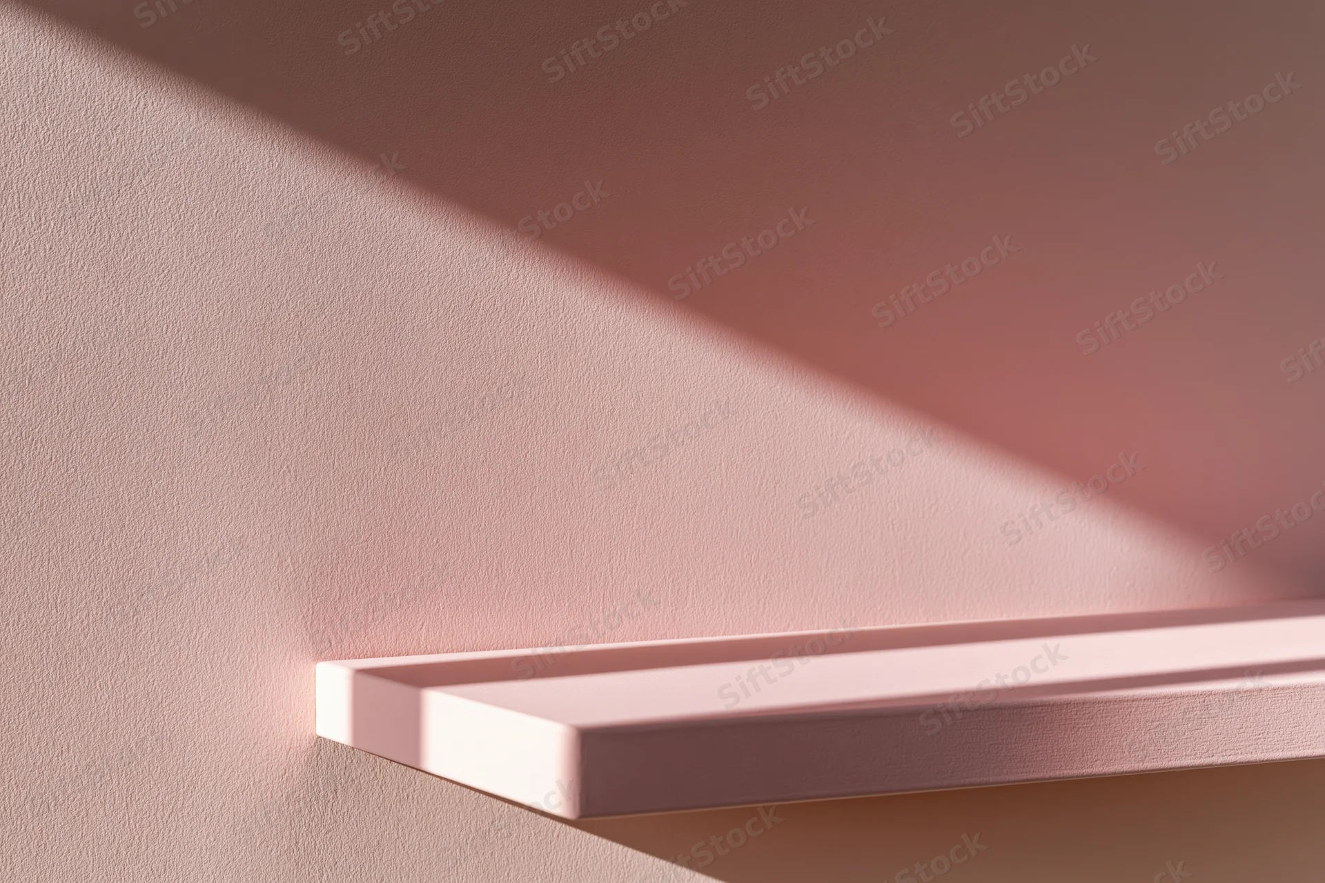 Empty blush-pink shelf mounted on a matching matte pink wall in a minimalist interior
