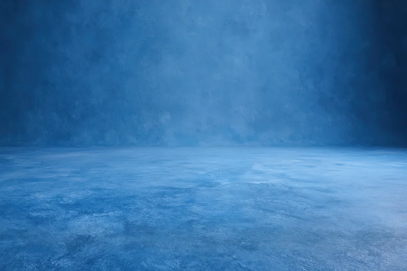 Seamless blue painted canvas backdrop for studio photography with empty floor and wall space