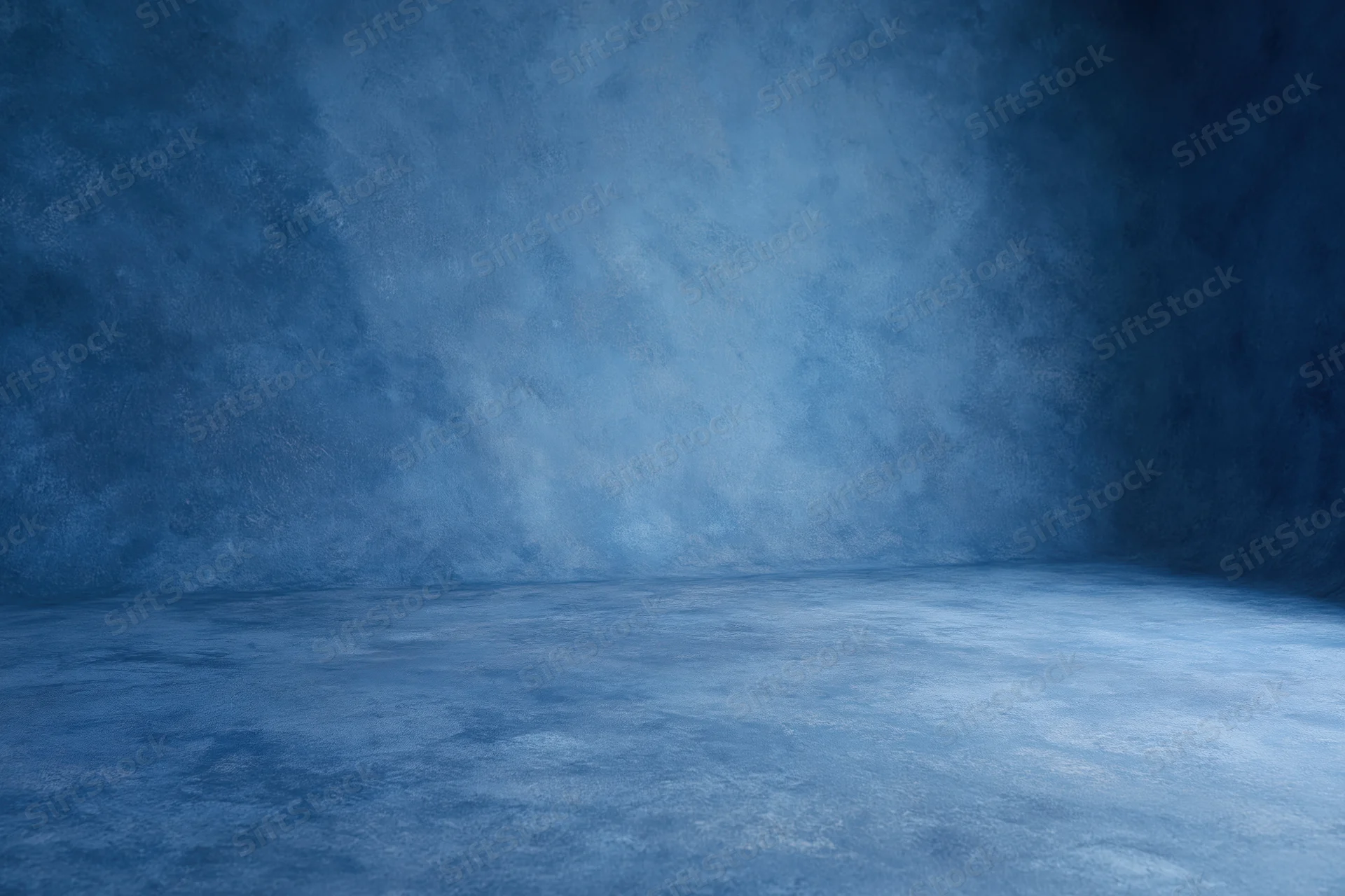 Seamless blue painted canvas backdrop in empty studio space