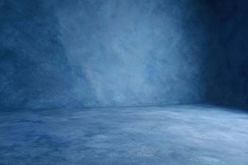 Seamless blue painted canvas backdrop in empty studio space