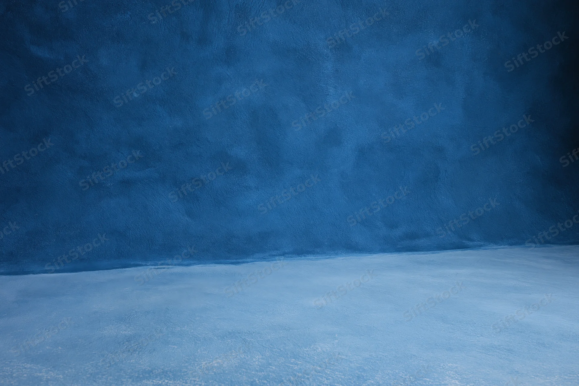 Seamless blue painted canvas backdrop in empty photography studio interior