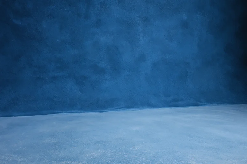 Seamless blue painted canvas backdrop in empty photography studio interior