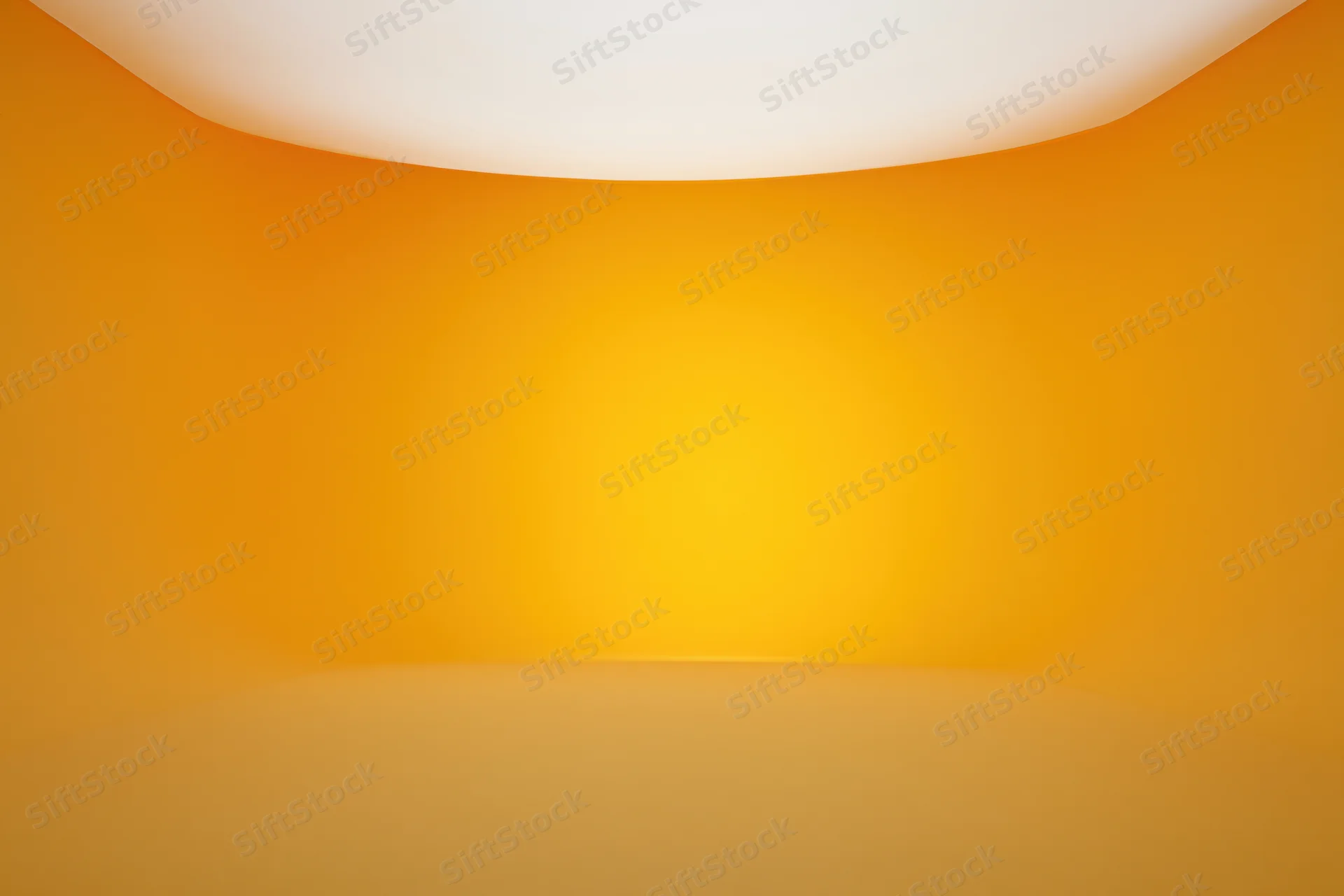 Empty studio space with seamless curved orange wall and floor transition