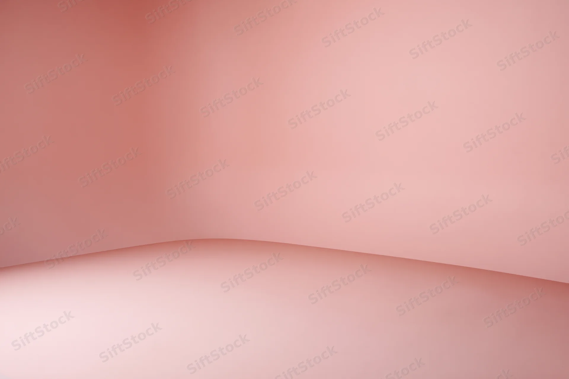 Seamless curved pink backdrop with floor-to-wall transition in empty studio space