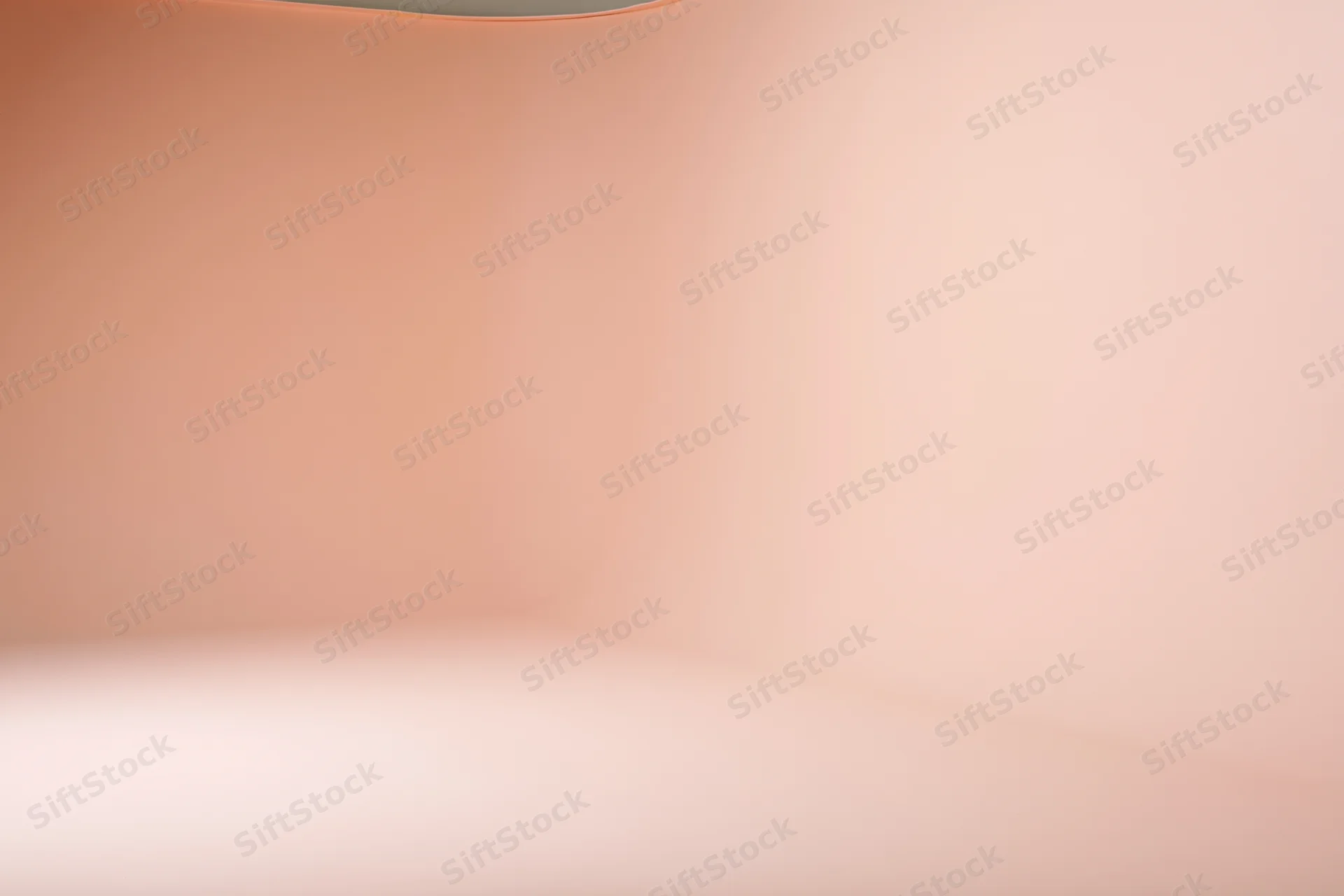 Seamless curved floor-to-wall backdrop in a studio with soft peach gradient lighting