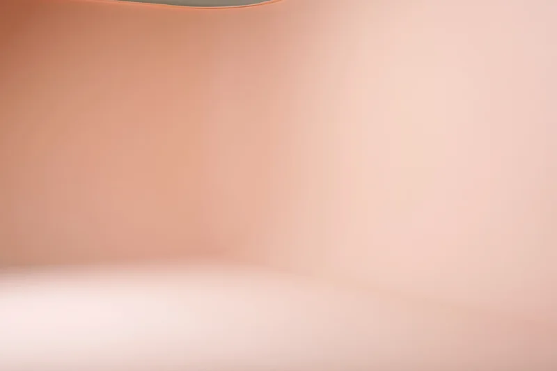 Seamless curved floor-to-wall backdrop in a studio with soft peach gradient lighting