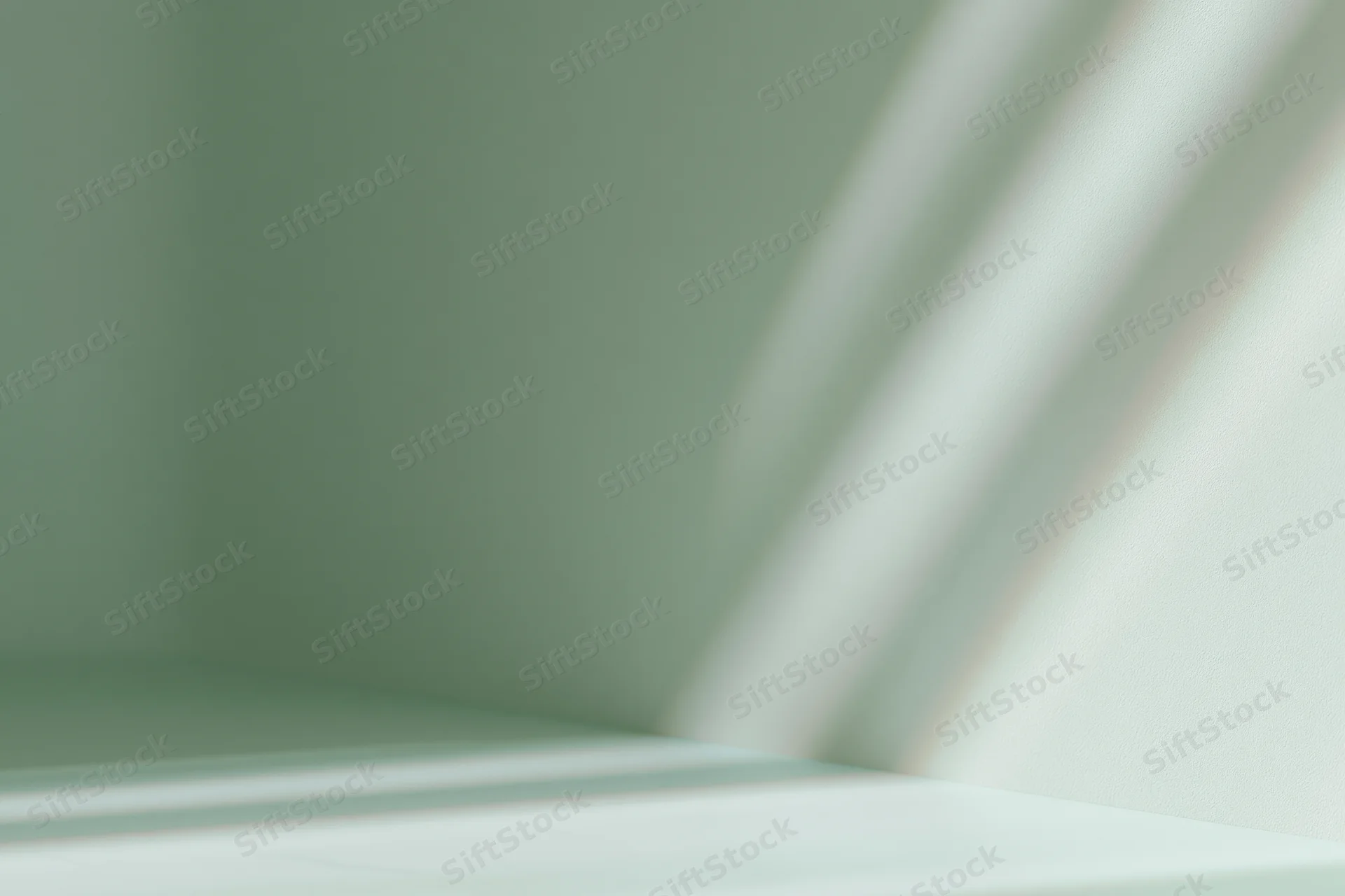 Seamless sage green studio backdrop with soft sunlight casting diagonal shadows on wall and floor