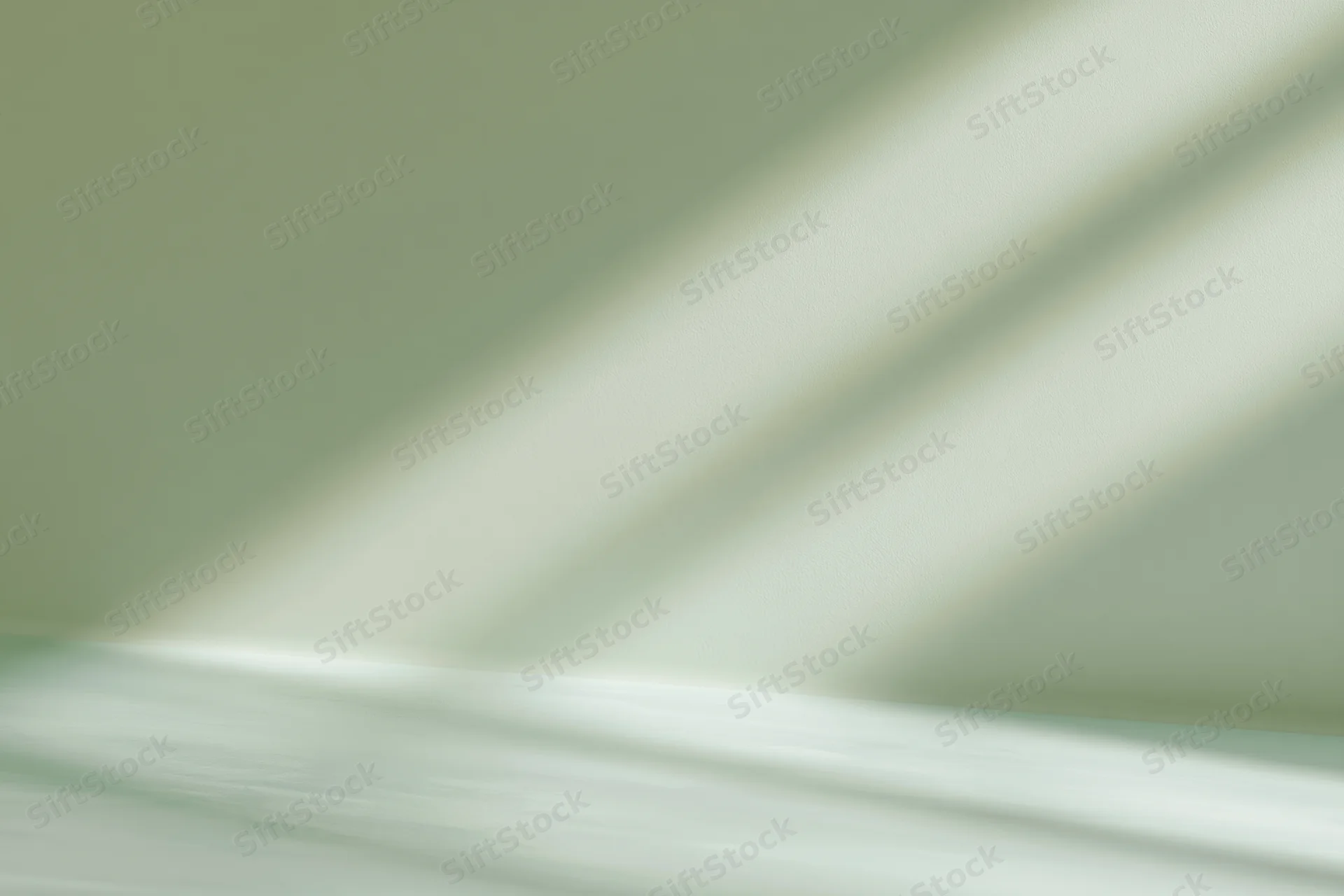 Seamless sage green studio backdrop with soft diagonal shadows and copyspace for product photography