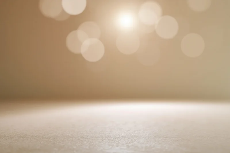 Empty studio backdrop with soft golden bokeh lighting and copyspace for product display