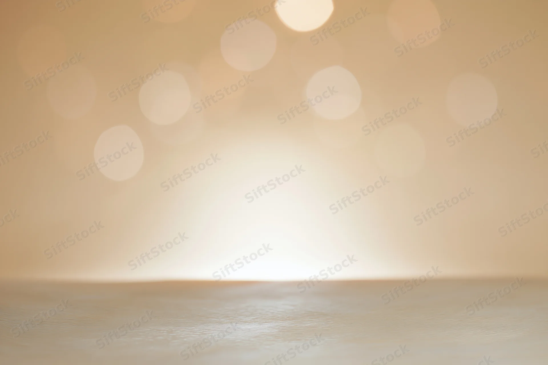 Empty studio backdrop with soft golden bokeh lights and wooden floor surface