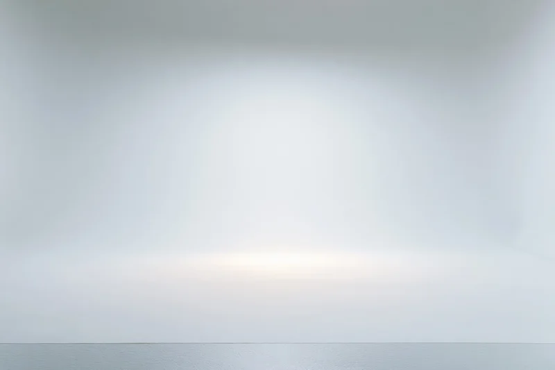 Seamless white paper backdrop in a photography studio with soft lighting and copyspace