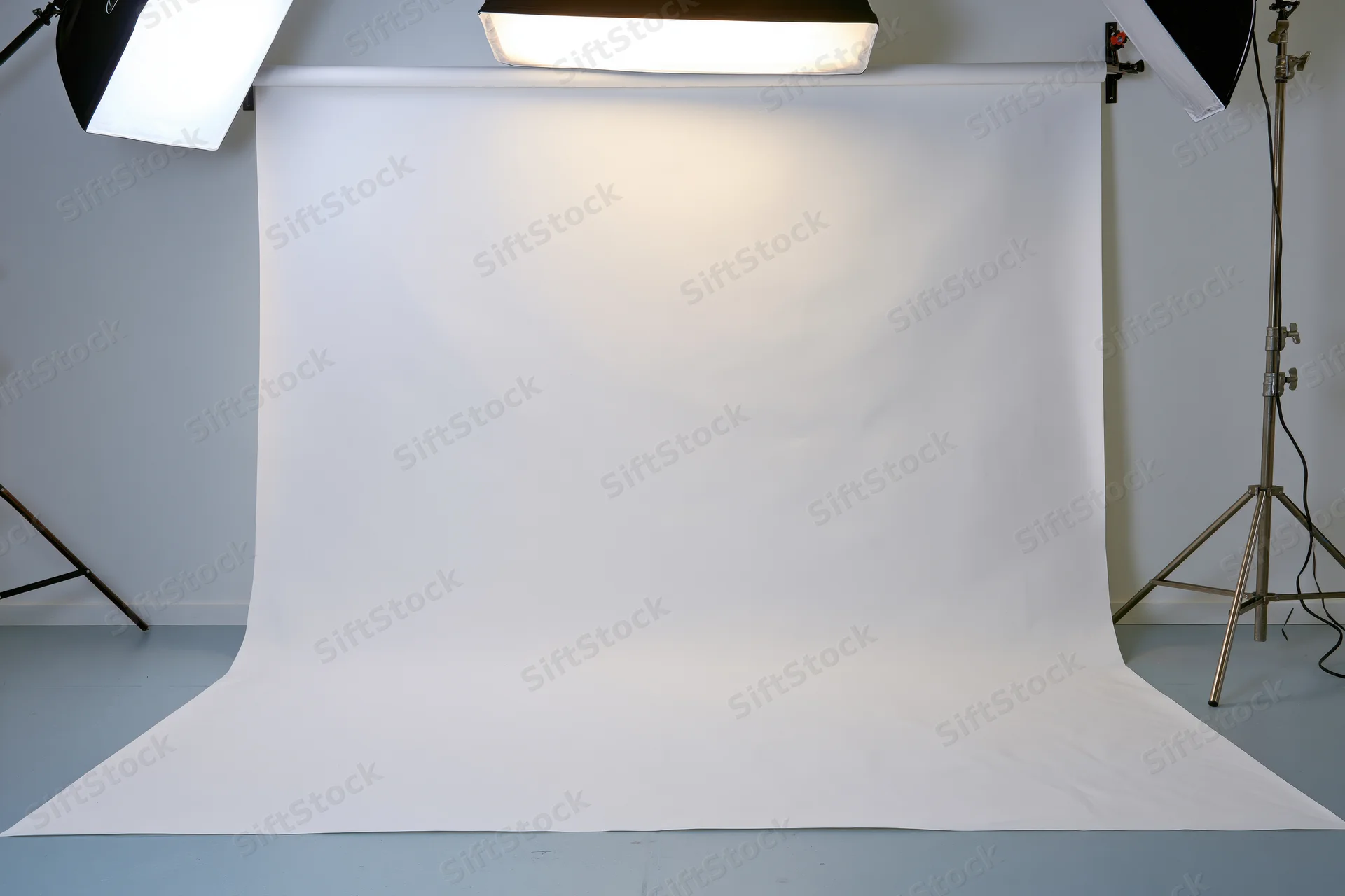 Seamless white backdrop in photography studio with lighting equipment and copyspace