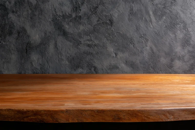 Empty wooden shelf against dark textured concrete wall with copyspace for product display