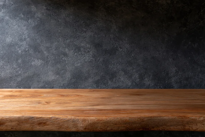 Empty wooden shelf against dark textured wall with copyspace for product display