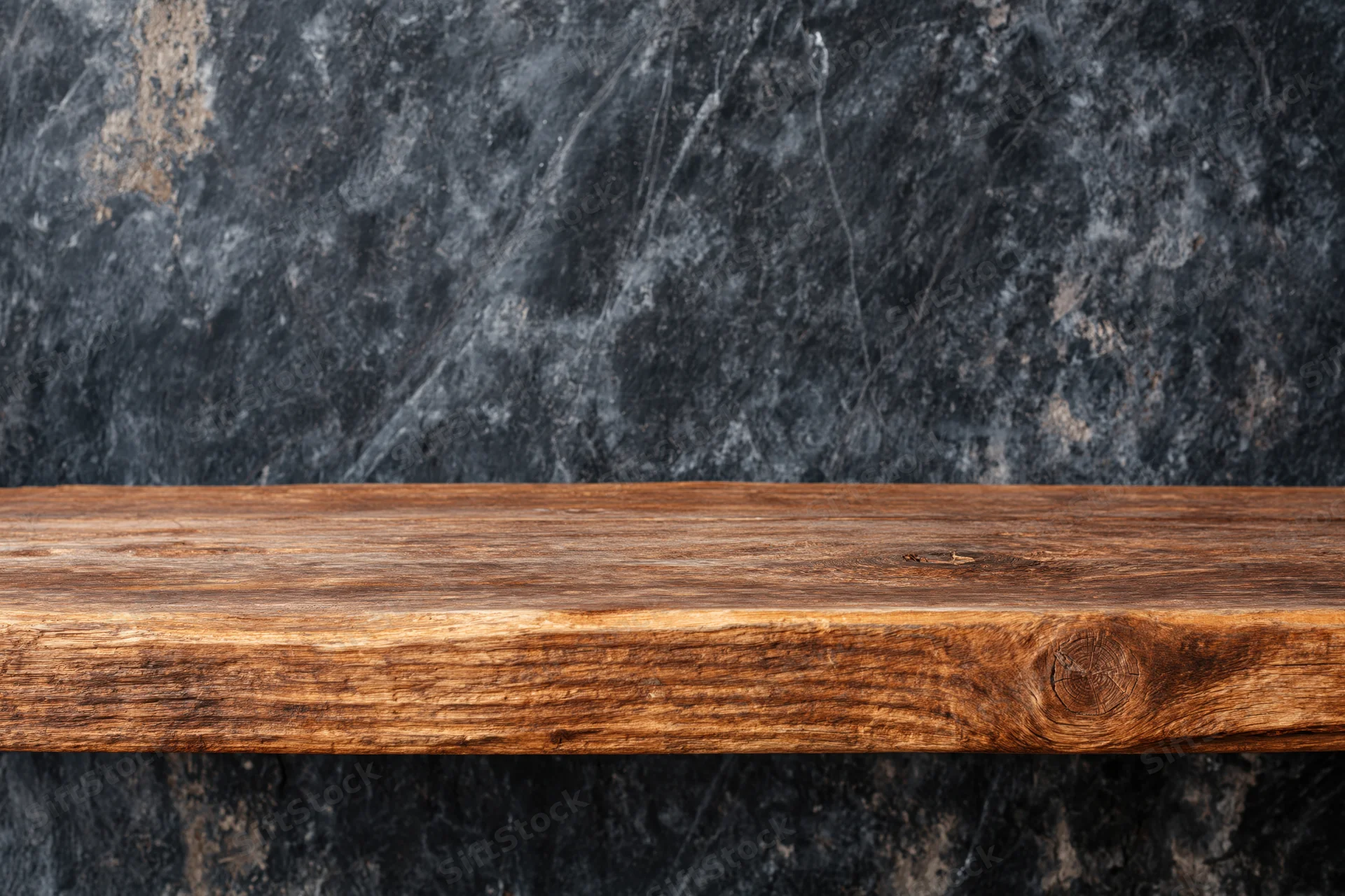 Empty worn wooden shelf surface against dark stone wall
