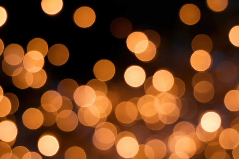 Out-of-focus string lights creating warm bokeh effect against dark background