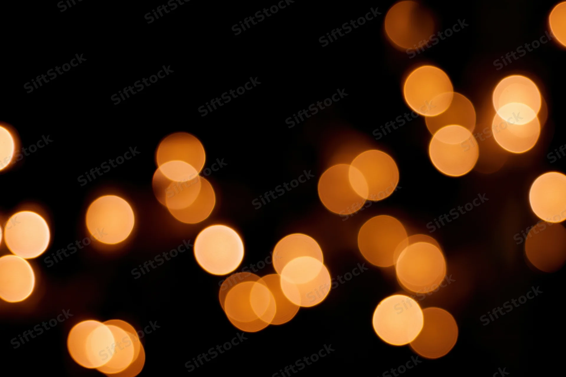Out-of-focus string lights glowing warmly against black background