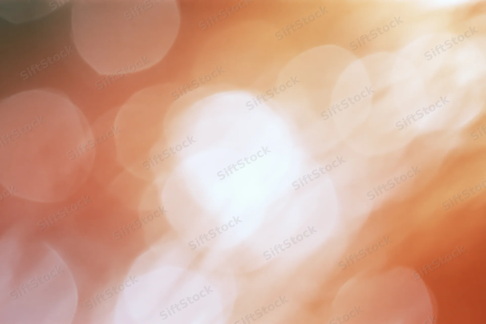 Warm light passing through in soft abstract blur with circular bokeh highlights
