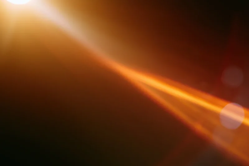 Warm light source creating lens flare and bokeh in abstract closeup