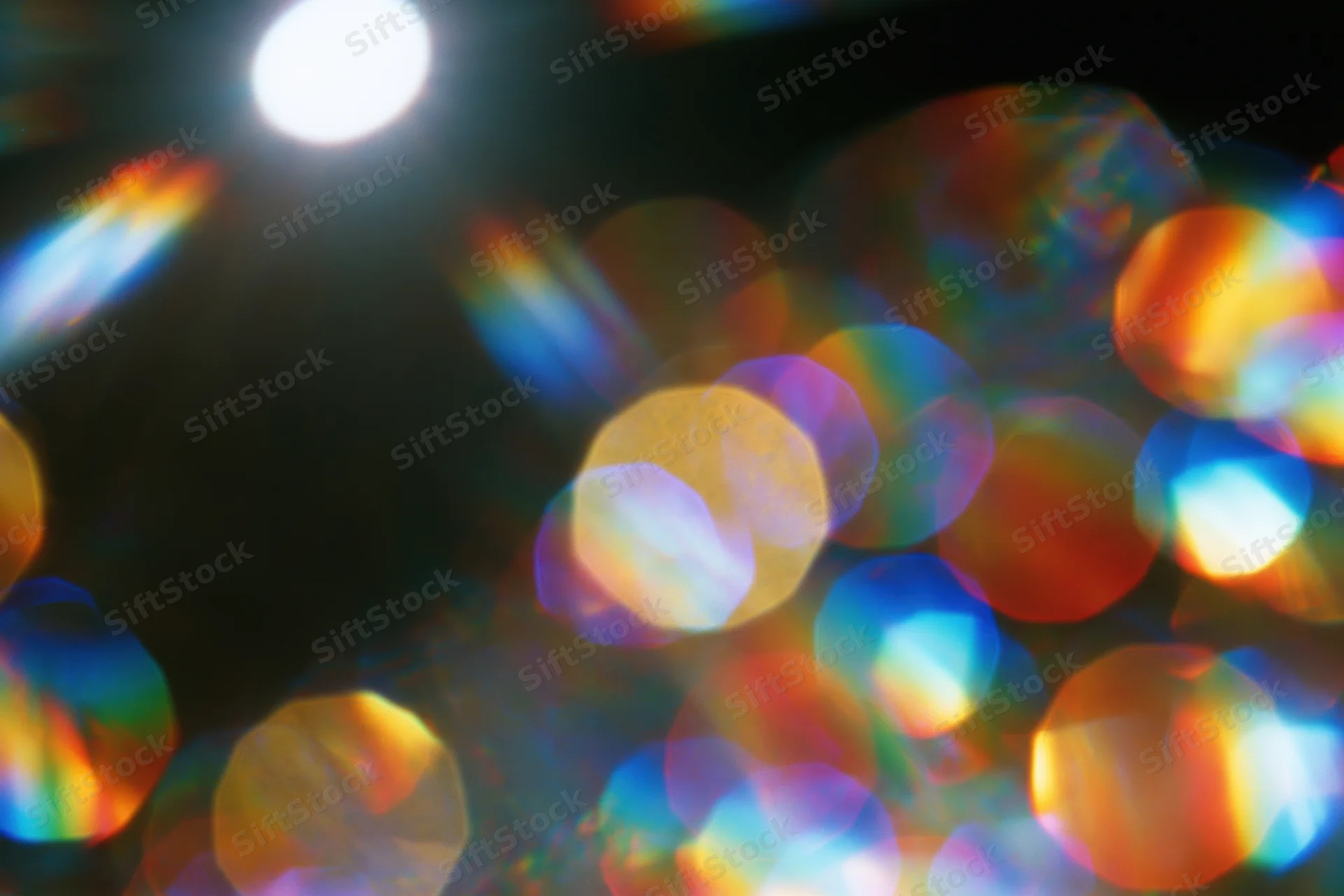 Abstract lens flare and bokeh light scatter with rainbow refraction patterns in soft focus