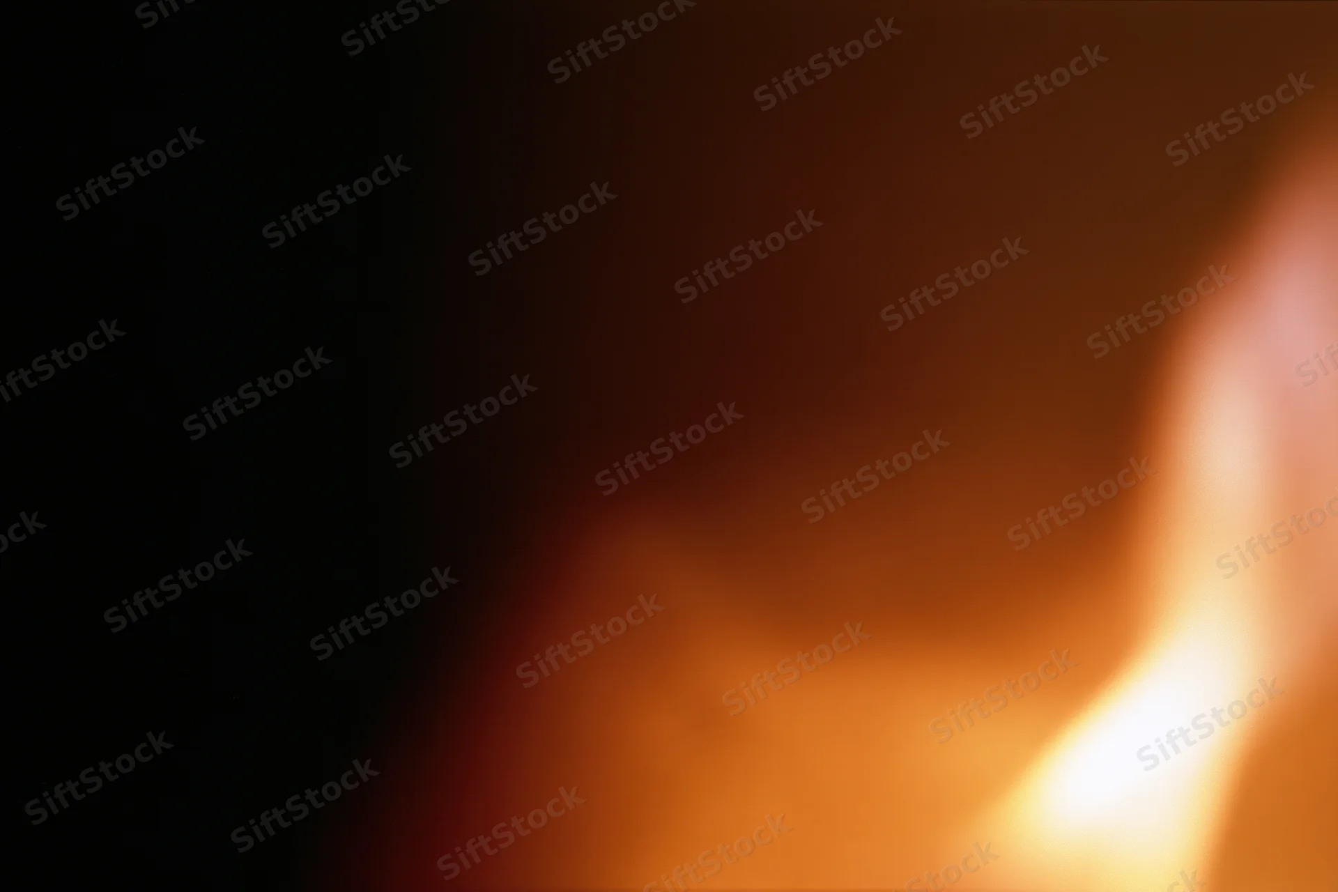 Extreme close-up of a flickering candle flame glowing warmly in dim light