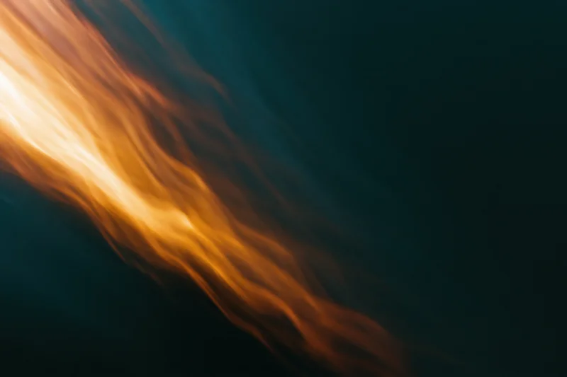 Warm amber light streaks moving diagonally across a dark background