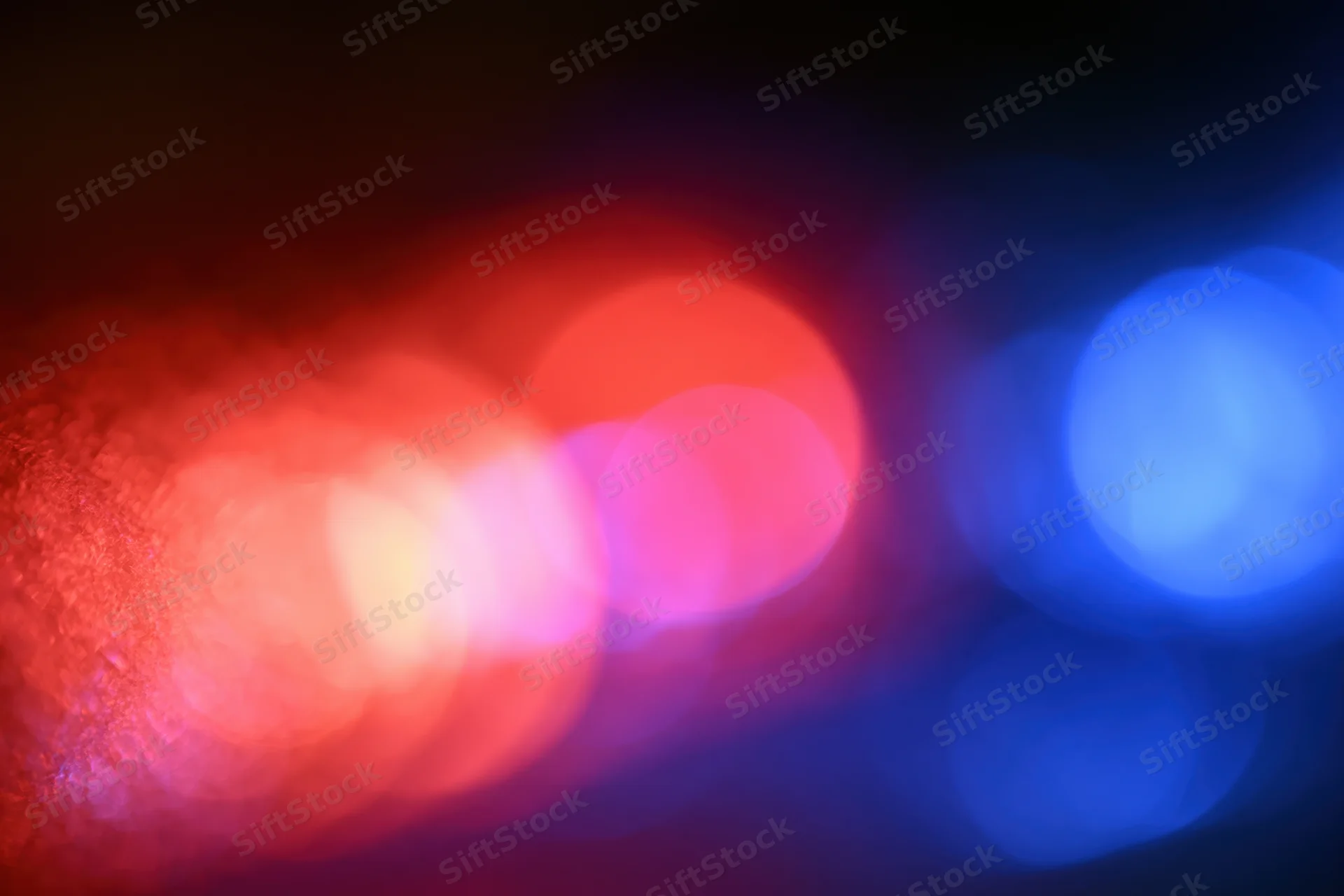Blurred red and blue emergency lights at night in extreme closeup